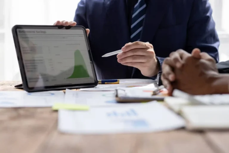 A professional consultant demonstrating upward financial growth on a tablet screen. At Kloudac, a premier accounting firm in Dubai, we provide data-driven accounting services to ensure sustainable business growth for our clients.