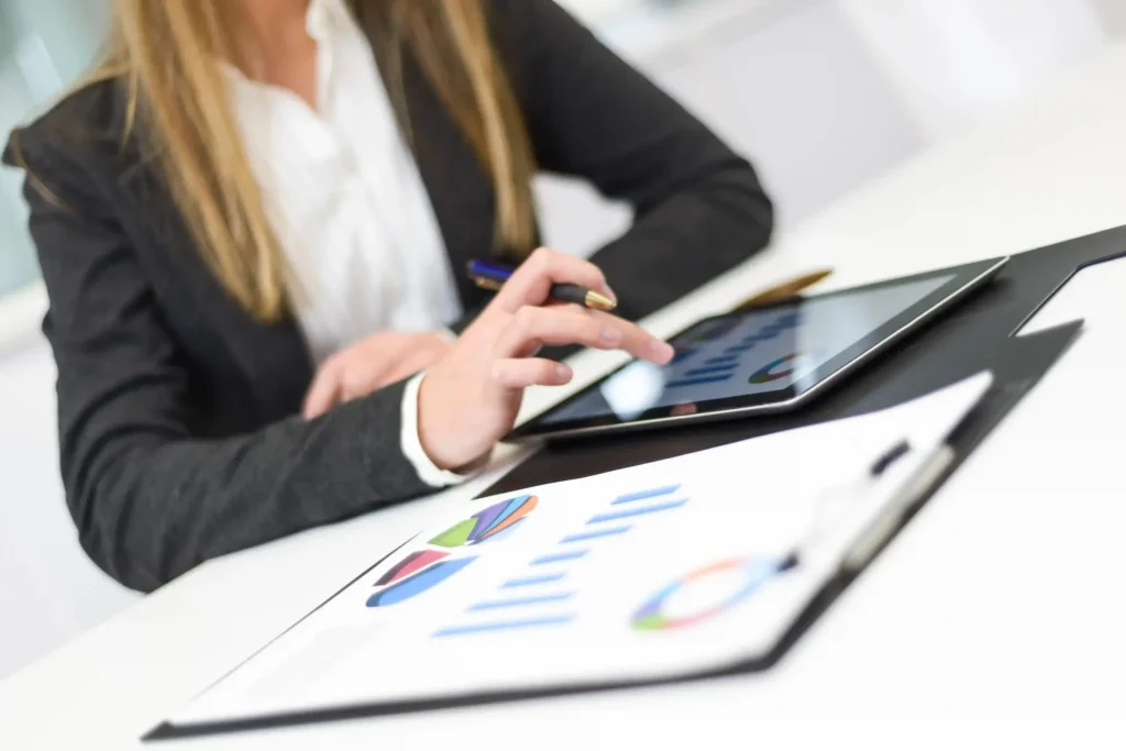 Expert consultation for accounting services in Dubai. A financial professional from a trusted accounting firm in Dubai analyzes business reports, charts, and financial data on a tablet.