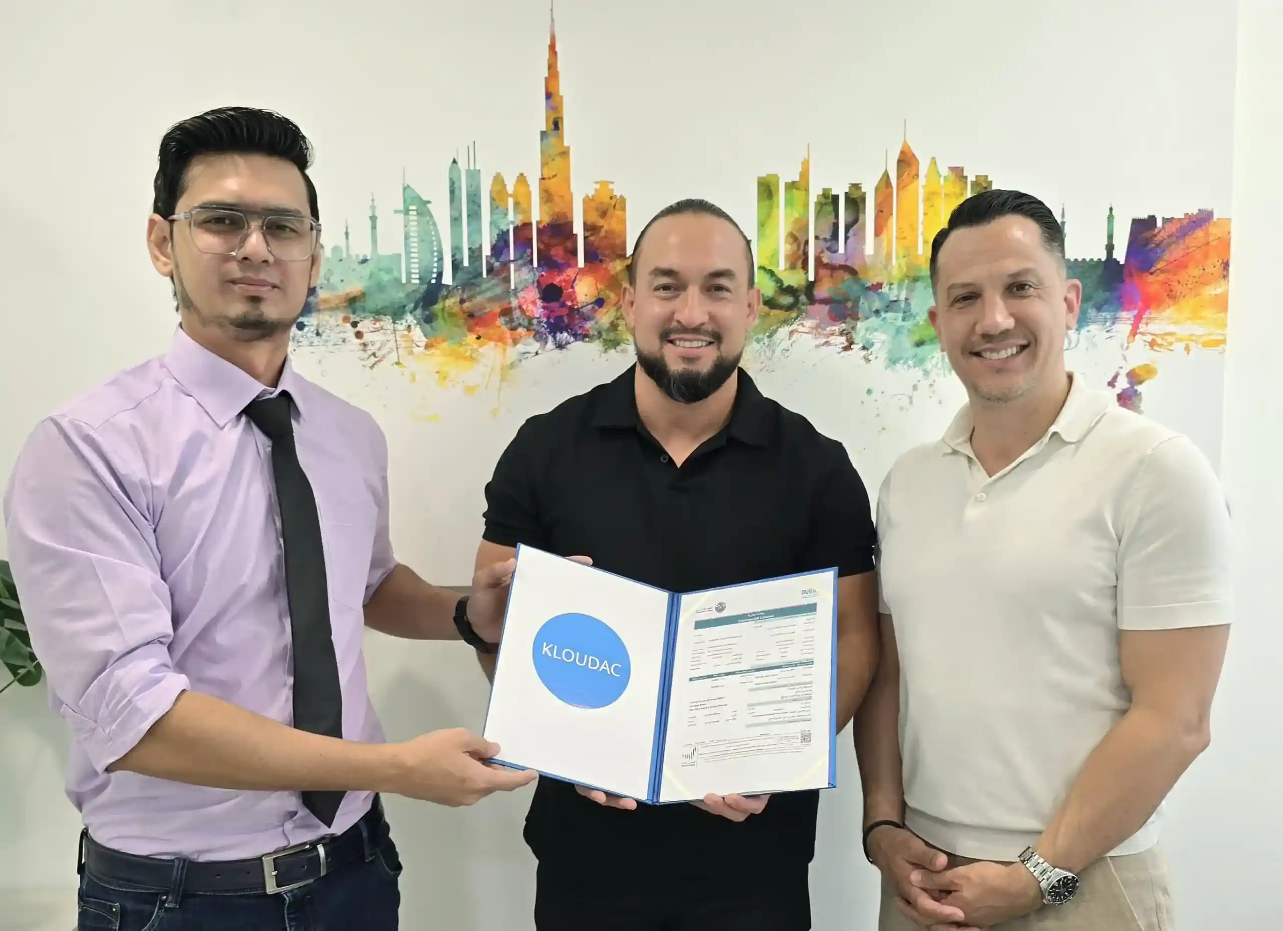 A professional consultant from Kloudac, a top Accounting firm, presenting a framed business trade license to a client. This successful business setup in Dubai highlights the comprehensive Accounting Services and corporate registration support provided to new business owners.
